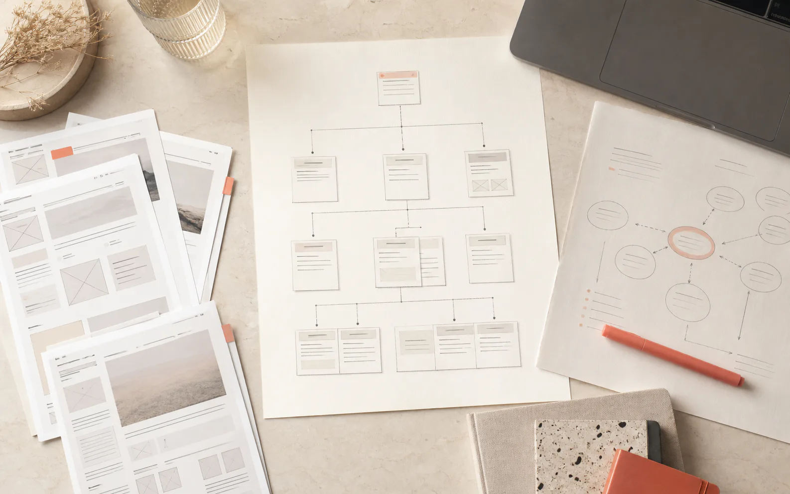 A website structure map and search-planning sheets arranged on a studio desk.